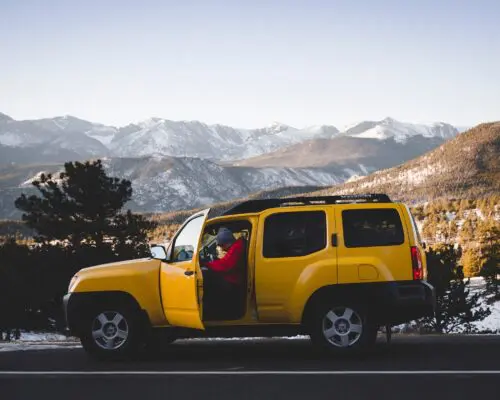 man getting out of car stopped on side of the road