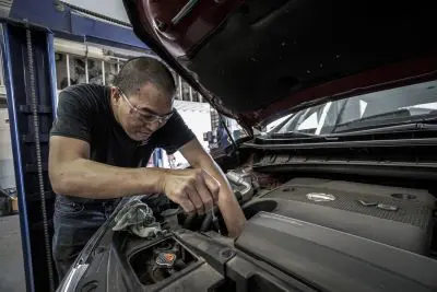 auto mechanic working on car engine