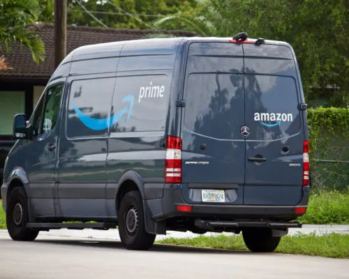 Amazon Prime delivery vehicle stops in residential neighborhood to deliver packages