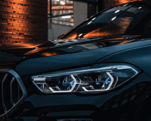 Up close shot of a cars headlight off at night time while driving