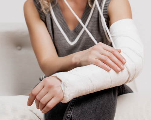 Person with an arm in a medical cast resting on their lap, illustrating an injury that may prevent someone from working and lead to a lost wages claim after an accident.