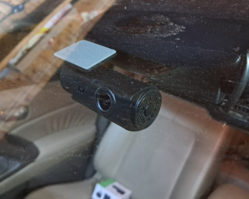 Dash camera mounted on a car windshield recording the road ahead, illustrating how video footage can capture evidence in a vehicle accident.