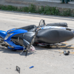 A crashed motorcycle lying on the roadway surrounded by debris, illustrating the severe impact of motorcycle accidents and the serious injuries riders often suffer.