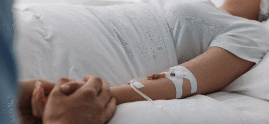 A patient with an IV receiving care in a hospital bed, symbolizing the life-altering damage of a catastrophic injury Colorado and the need for long-term care.