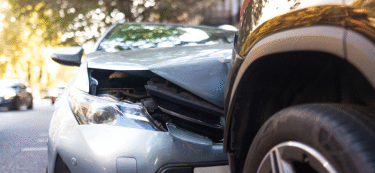 Front end of a damaged car after a collision with another vehicle on a residential street, illustrating a Colorado Springs car accident and the concept of diminished value claims for reduced resale value after repairs.