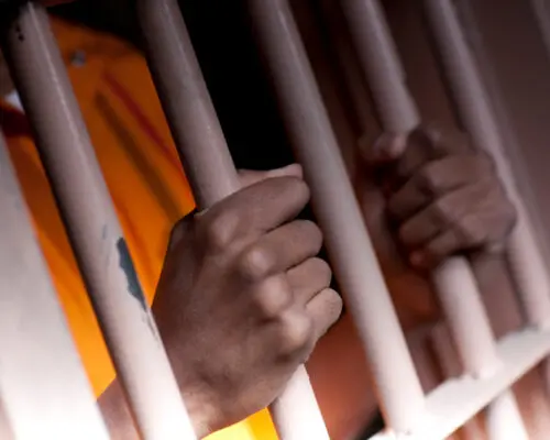 person behind bars in jail