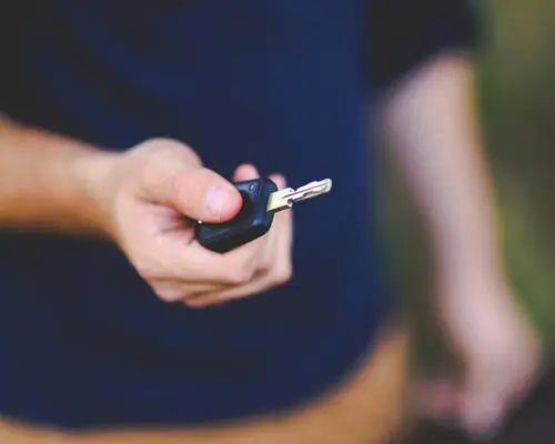 A man's hand holding a car key.