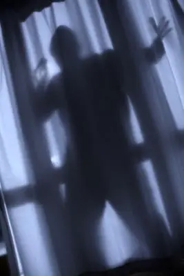 silhouette of burglar behind window