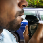 Close-up of a driver taking a breathalyzer test during a roadside stop, illustrating DUI testing procedures and legal considerations in Black Forest, Colorado.
