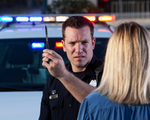 Police officer administering a roadside sobriety test during a traffic stop, illustrating potential reliability issues with motorcycle field sobriety tests in Colorado Springs DUI cases.
