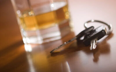 Glass of whiskey on a table next to car keys