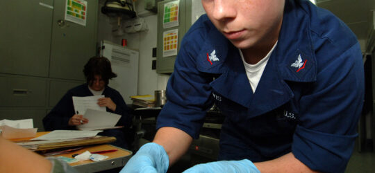 Medical professional taking a blood sample from a persons arm