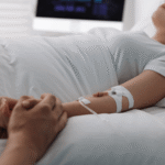 A patient with an IV receiving care in a hospital bed, symbolizing the life-altering damage of a catastrophic injury Colorado and the need for long-term care.