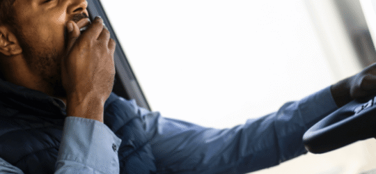 Fatigued truck driver yawning behind the wheel