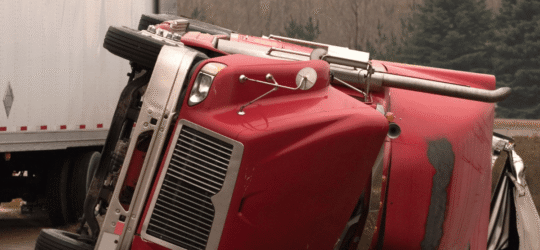 Overturned red semi-truck after crash